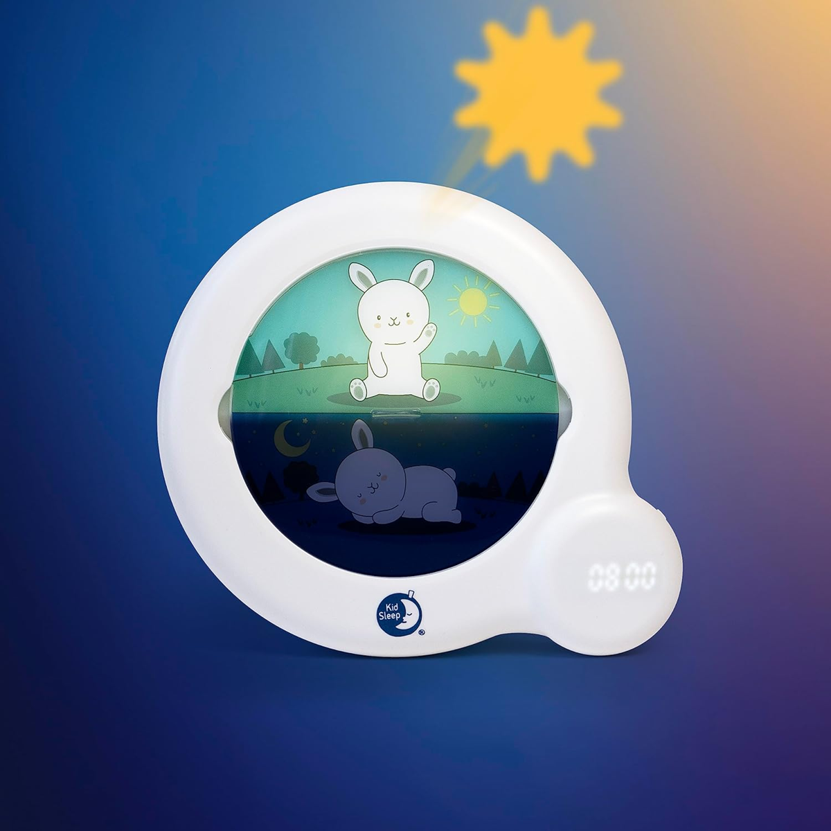 Pabobo Kid'Sleep Essential z ilustracją królika; na ścianie za urządzeniem widoczny żółty symbol słońca.