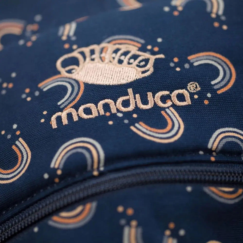 Zbliżenie haftowanego logo Manduca na tkaninie we wzór tęczy.